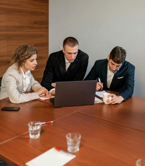 Team in boardroom around laptop